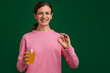 © New Africa - Happy woman with glass of juice showing okay gesture on green background. Space for text