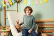 © New Africa - Little boy with cute Easter bunny in armchair indoors