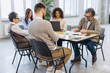 © anatoliycherkas - Diverse business professionals having a team meeting, collaborating and planning in a modern office environment