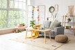 © Pixel-Shot - Interior of light living room with Easter wreath, sofa and table