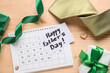 © Pixel-Shot - Gift boxes with greeting card, calendar, tie and ribbon on brown wooden background. Father's day celebration