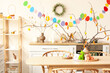 © Pixel-Shot - Vase with tree branches, Easter rabbits and eggs on dining table in kitchen