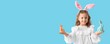 © Pixel-Shot - Cute little girl with Easter bunny ears and toy rabbits on blue background with space for text