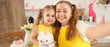 © Pixel-Shot - Happy mother and her cute daughter in aprons with freshly baked Easter cakes taking selfie at home