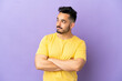© luismolinero - Young caucasian man isolated on purple background looking to the side