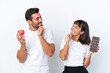 © luismolinero - Young couple holding chocolate and apple isolated on white background looking looking at each other