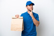 © luismolinero - Delivery caucasian man isolated on white background having doubts while looking up