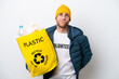 © luismolinero - Young caucasian holding a bag full of plastic bottles to recycle isolated on white background and looking up