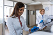 © Graphicroyalty - Young Female Scientist Working with Laboratory Equipment, Healthcare and Medicine concept. Professional researcher in white coat and gloves conducting clinical test and biotechnology research.