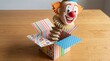 © Irina - Clown popping out of colorful surprise box representing April Fool’s Day