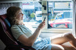 © Aleksej - Woman using smartphone while sitting in comfortable sleeper bus seat during long distance travel in Southeast Asia
