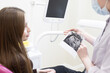 © Victoria - a dentist shows a dental x-ray to a patient. Doctor shows the patient an x-ray image. Computer diagnostics. dental tomography