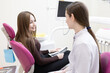 © Victoria - A dentist consults a patient with a dental x-ray. A dentist shows a patient an X-ray