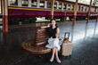 © Parichat - Asian woman traveling, talking on phone at train station