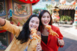 © Parichat - Young Asian women enjoying street food travel selfie