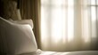 © yi - Hotel bed with crisp white linens and decorative pillow in soft morning light through sheer curtains.