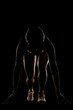 © Nikola Spasenoski - Young female runner preparing for a race in low light, highlighting dedication and athleticism