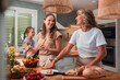 © PintoArt - Family generations cooking healthy meal enjoying time together