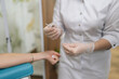 © dikushin - Close-up cropped shot of unrecognizable patient receiving blood test preparation from medical professional, getting blood sample drawn for laboratory analysis in clinical healthcare environment.