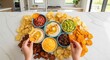 © Nataly - Colorful chip dip platter featuring assorted snacks with hummus, salsa, guacamole. Chip dip platter presents various delicious dips, crispy tortilla chips on white marble countertop.