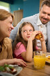 © Viacheslav Yakobchuk - Both parents and their daughter share laugh at dining table