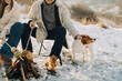 © dsheremeta - Family enjoying winter campfire with pet dog