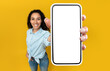 © Prostock-studio - Mobile App Advertisement. Happy Woman Showing Big White Empty Smartphone Screen Close Up To Camera, Recommending App On Orange Studio Wall, Selective Focus On Hand. Check This Out, Cellphone Display