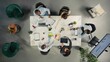 © DC Studio - Top down view of employees consulting with executive management during briefing. Graphs and visual data illustrating key insights, goals and metrics for business administration.