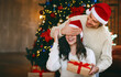© Prostock-studio - Loving young handsome man giving surprise gift to his wife, closing her eyes, celebrating Christmas at home
