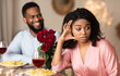 © Prostock-studio - Friendzone Concept. Dissatisfied frustrated african american woman rejecting excited emotional obsessed black guy who offering her bunch of red roses, young couple having bad date