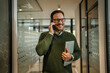 © Miljan Živković - Smiling business man walking and talking on phone