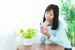© taka - 困った顔をしてスマートフォンを使う女性
