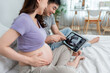 © Kawee - Asian young couple watching their baby's ultrasound on digital tablet.
