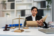 © Kawee - Asian lawyer working with gavel and scales of justice in courtroom office.