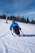 © Alex - A wheelchair user rides down a mountain on a monoski.