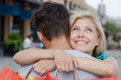 © auremar - woman hugging man in the street while holding shopping bags