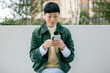 © Westend61 - Woman sitting outdoors enjoying break using smartphone in jacket