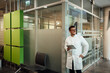 © Westend61 - Doctor in white coat smiling with tablet in modern hospital corridor
