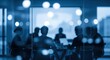 © joharia - Blurred Silhouettes of Business People in a Modern Office Meeting Room.
