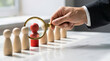 © Aiustock - Recruitment, A Person Holding A Magnifying Glass Over A Red Wooden Figurine, Identifying A Standout Candidate For Job Selection