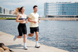 © muse studio - Couple jogging by the riverbank in the city on a sunny day in the morning
