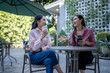 © Wasana - Women friends enjoying coffee and talking at outdoor cafe