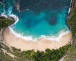 © AmazingAerialAgency - Aerial view of Kelingking Beach's dramatic cliffs plunging into the turquoise sea, with white sand meeting the foamy waves, Klungkung Regency, Bali, Indonesia.