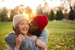 © Jelena - Interracial couple sharing happy kiss in sunny autumn park