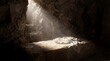 © Artem Zatsepilin - empty stone tomb with folded linen cloth on rock slab. light beams shining from entrance. jesus christ resurrection concept. easter holiday background. church banner, website header.