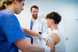 © Halfpoint - Doctor giving flu vaccine to teenage boy in medical clinic.