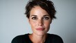 © svastix - A stunning woman with short hair gazes into the camera, her expressive eyes and natural beauty highlighted by soft lighting, creating a calming and intimate portrait.