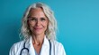 © svastix - A confident and approachable female doctor stands proudly in front of a teal background, showcasing her professional demeanor and dedication to patient care and wellbeing.