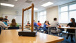© Valeriy - Students engaging in physics lesson with Newton's cradle, educational impact