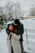 © BGStock72 - Korean woman and Caucasian man share a warm moment in snowy park during winter